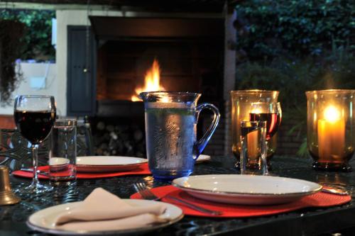 a table with plates and glasses on a table with a fireplace at Claires of Sandton Luxury Guest House in Johannesburg