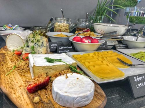 a table with different types of cheese and other foods at IBB Hotel Gdańsk in Gdańsk
