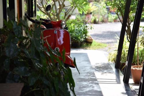 a red scooter parked on the side of a house at Rest Time Hotel in Nong Khai
