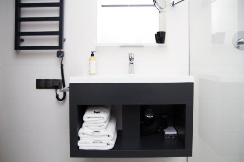 a bathroom with a sink with towels under it at IBB Hotel Gdańsk in Gdańsk