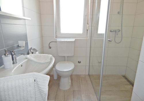 a bathroom with a toilet and a sink and a shower at Apartments Katarina with swimming pool in Stobreč