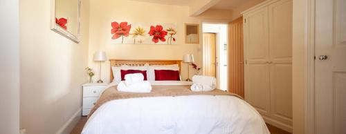 a bedroom with a bed with two towels on it at Garden Apartment, 2 Pilots Point in Totland
