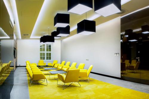 a conference room with yellow chairs and tables and lights at IBB Hotel Gdańsk in Gdańsk