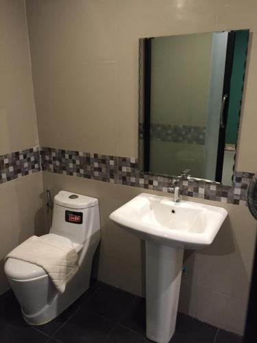 a bathroom with a sink and a toilet and a mirror at Rest Time Hotel in Nong Khai