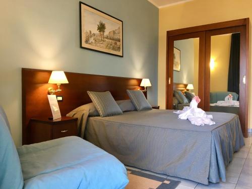 a bedroom with two beds with a stuffed animal on top at Grand Hotel L'Approdo in Terracina