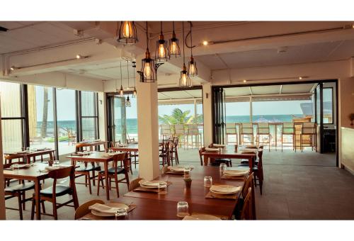 a dining room with tables and chairs and a large window at Malibu Koh Samui Resort & Beach Club - SHA Extra Plus in Chaweng