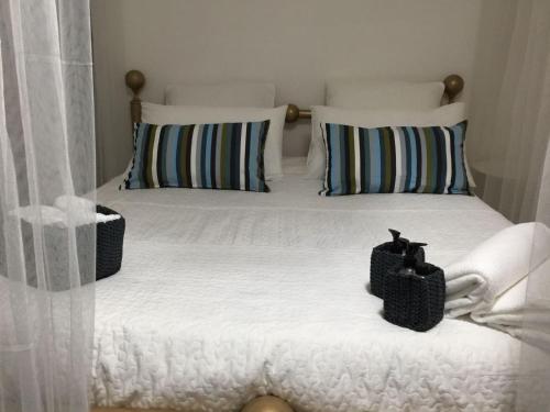 a bed with white sheets and two pillows at Style di Elisabetta Notari in Borghesiana 