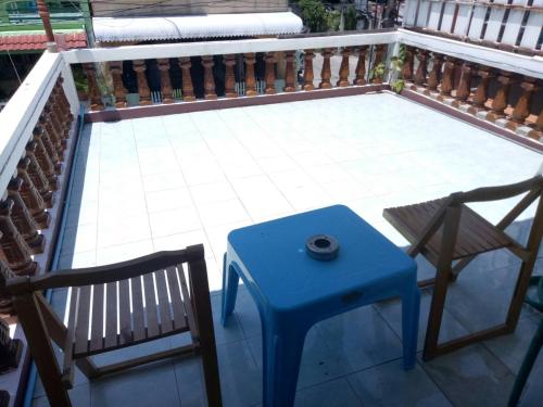 a blue stool and a chair on a balcony at TG2 - Tientong Guesthouse 2 in Hua Hin