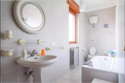 bagno bianco con lavandino e specchio di Casa Vacanze Civico 19 a Matera