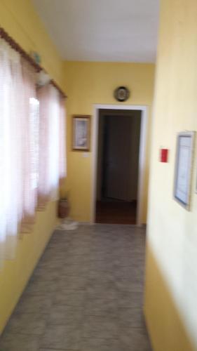 an empty hallway with yellow walls and a door at Panorama Kakopleyri Kalabakas in Kakoplévrion