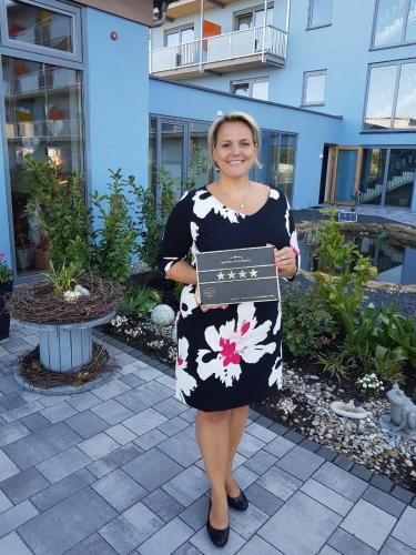 a woman in a black and white dress holding a sign at Vital Hotel an der Therme GmbH in Bad Windsheim