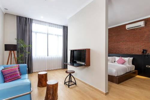 a living room with a blue couch and a bed at S Loft Manado in Manado