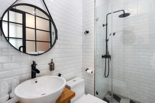 a white bathroom with a sink and a mirror at S Loft Manado in Manado