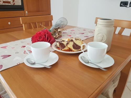 un tavolo con due tazze e un piatto di torta di A Casetta a Putignano