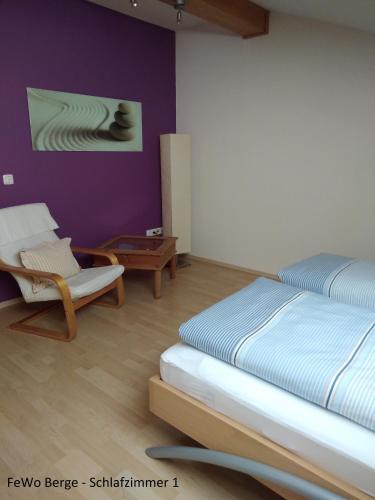 a bedroom with a bed and a chair at Haus Ellerbeck in Bodenmais