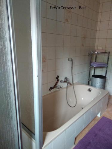 a bath tub with a shower in a bathroom at Haus Ellerbeck in Bodenmais