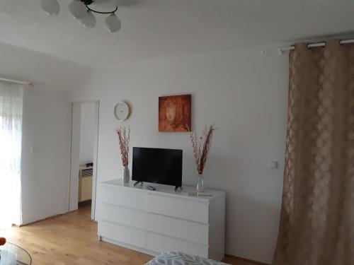 una sala de estar con TV en una cómoda blanca en Apartment Nada, en Belišće
