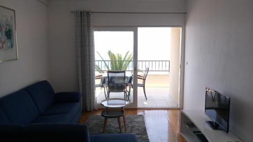 a living room with a couch and a tv and a table at Apartments Gaston in Podgora