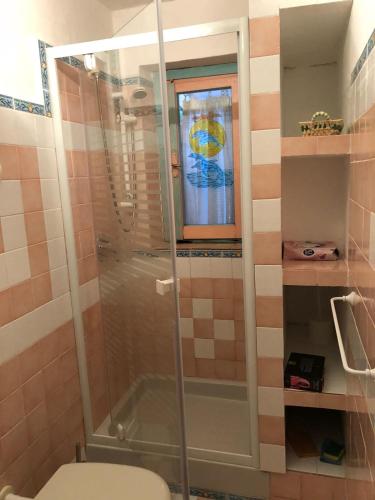 a bathroom with a shower with a toilet and a window at Casa UGB in Cannigione