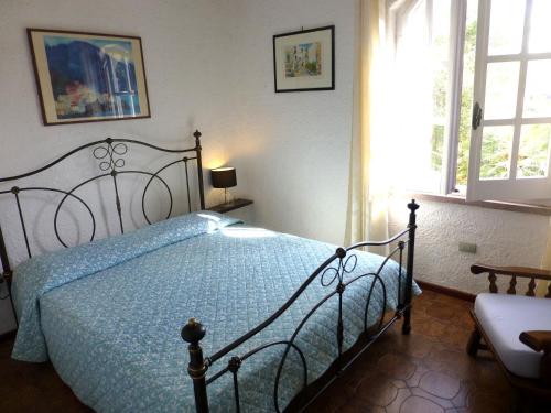 a bedroom with a bed with a blue comforter at Villa Anna Maria in Santa Margherita di Pula