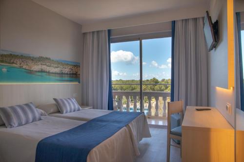 a hotel room with a bed and a balcony at Seramar Hotel Luna Park Adults Only in El Arenal