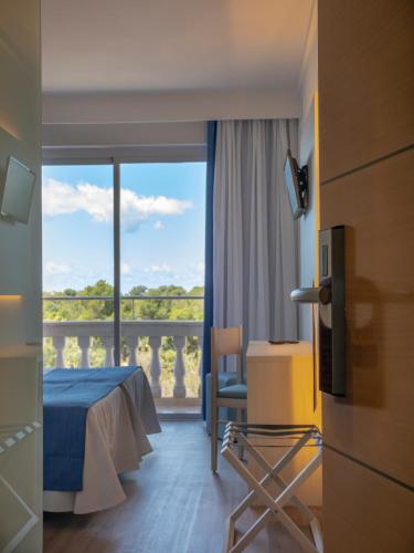 a hotel room with a bed and a balcony at Seramar Hotel Luna Park Adults Only in El Arenal
