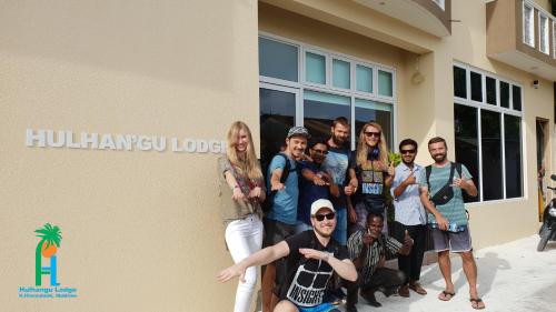 a group of people standing in front of a building at Hulhan'gu Lodge in Himmafushi