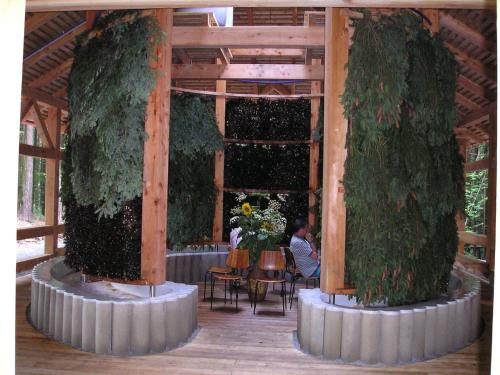 a person sitting at a table in a pavilion with trees at Kirchenwirt Durlacher in Kaibing