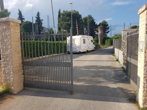 uma caravana está estacionada atrás de uma cerca com um portão em A Casetta em Putignano