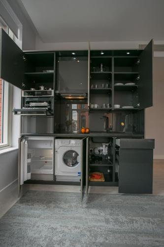 a kitchen with black cabinets and a dishwasher at Grafton Street Studios by City Break Apartments in Dublin