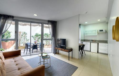 a living room filled with furniture and a tv at Sea Land Suites in Tel Aviv