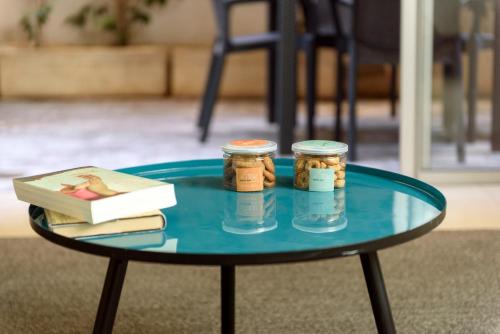 a glass table with two jars and a book on it at Sea Land Suites in Tel Aviv