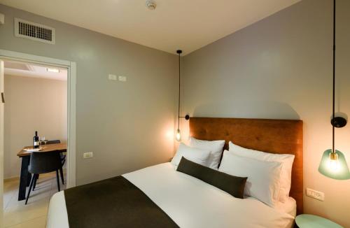 a bedroom with a bed and a table and a desk at Sea Land Suites in Tel Aviv