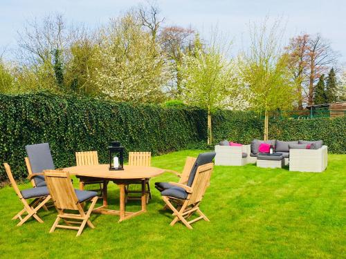 eine Terrasse mit einem Tisch, Stühlen und einem Sofa in der Unterkunft B&B Villa Curtricias in Kortessem