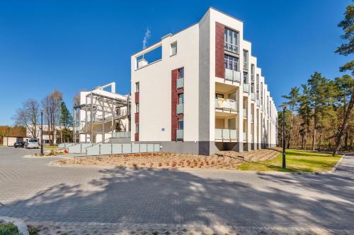 a large white building on the side of a street at Bursztynowe Osiedle Jantar, Sun & Snow in Jantar