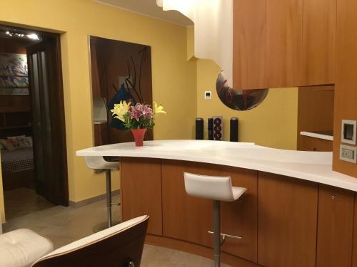 a kitchen with yellow walls and a counter with flowers on it at Mon Amour appartamento in villa vista lago a Lugano-Melide in Melide