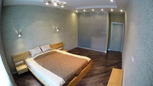 ノヴォシビルスクにあるApartments on Leninaのベッドルーム1室(ベッド1台付)、壁に照明が付いています。