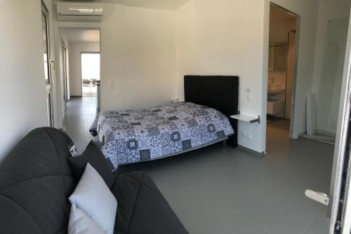 サリ・ソランザラにあるCorsicacasa Appartement Sur La Mer Port De Solenzaraのベッドルーム1室(ベッド1台、ソファ付)