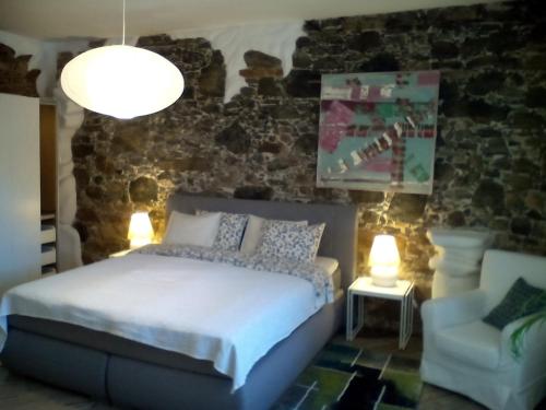 ein Schlafzimmer mit einem Bett, einem Stuhl und Lampen in der Unterkunft Appartement Donaustrand in Bergern