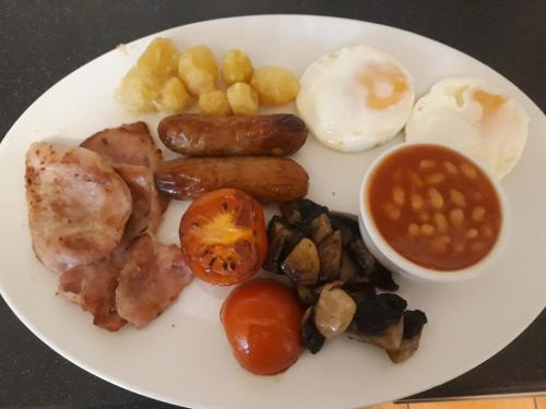 een bord met eieren, worstjes, tomaten en bonen bij Cherrylee in Sandown