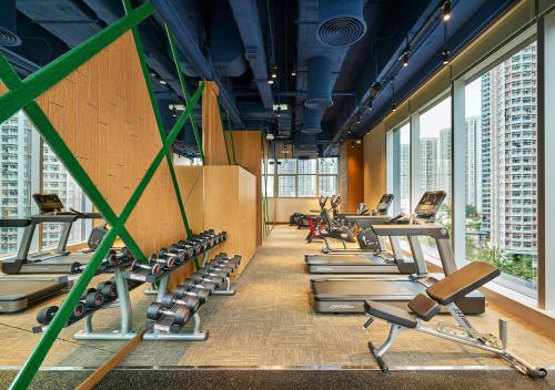 a gym with rows of exercise equipment in a building at Hotel COZi Wetland in Hong Kong