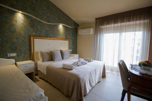 a hotel room with two beds and a window at Hotel Lady Mary in Milano Marittima
