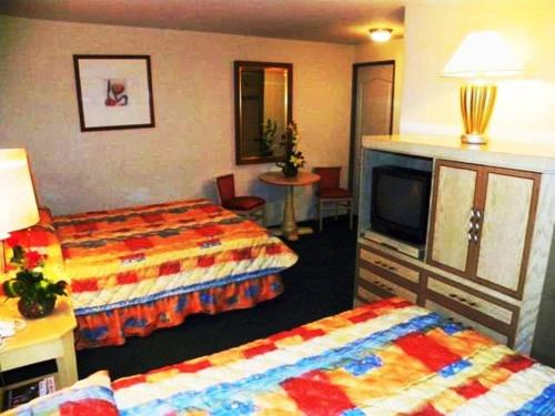 Una habitación de hotel con dos camas y un televisor. en Hotel San Francisco Irapuato Business Class, en Irapuato