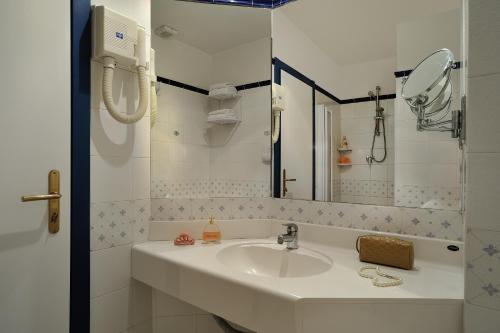 a white bathroom with a sink and a mirror at Hotel Ascot Riccione in Riccione