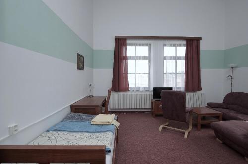a room with a bed and a couch and a chair at Koleje Zamecek in Lednice