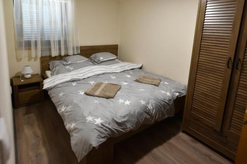 a bed in a bedroom with two towels on it at Sirály Apartman in Hajdúnánás