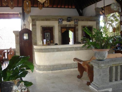 a lobby with a bar with plants in it at Tamukami Hotel in Sanur