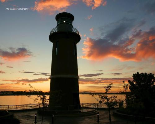 a lighthouse in front of the water at sunset at Clover Island Inn in Kennewick