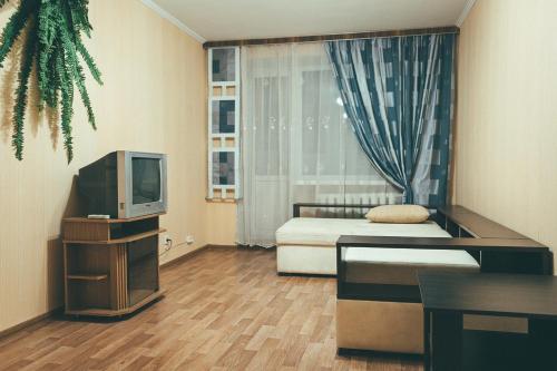 チェルニーヒウにあるPrime Home 2のベッド1台とテレビが備わる小さな客室です。
