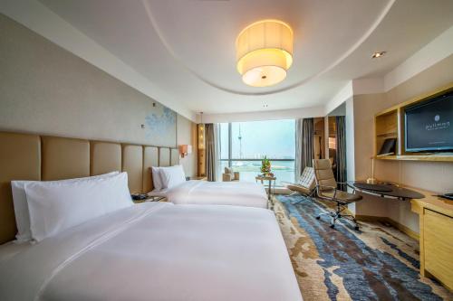 een hotelkamer met 2 bedden en een televisie bij Pullman Linyi Lushang in Linyi